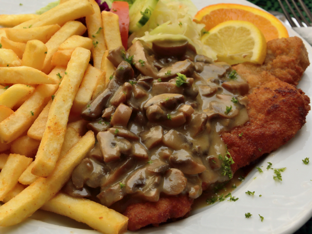 Authentic German Jaegerschnitzel with breaded pork cutlets and mushroom gravy