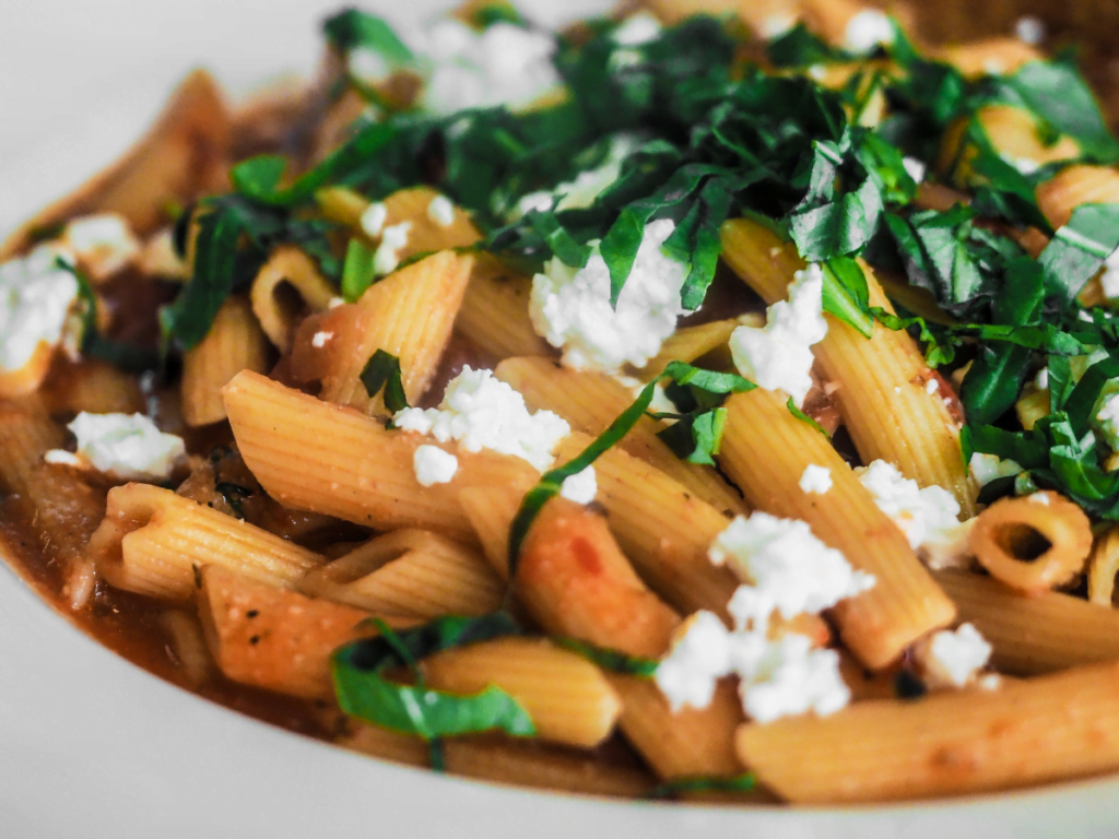 Pasta salad with feta cheese, fresh vegetables, and light vinaigrette