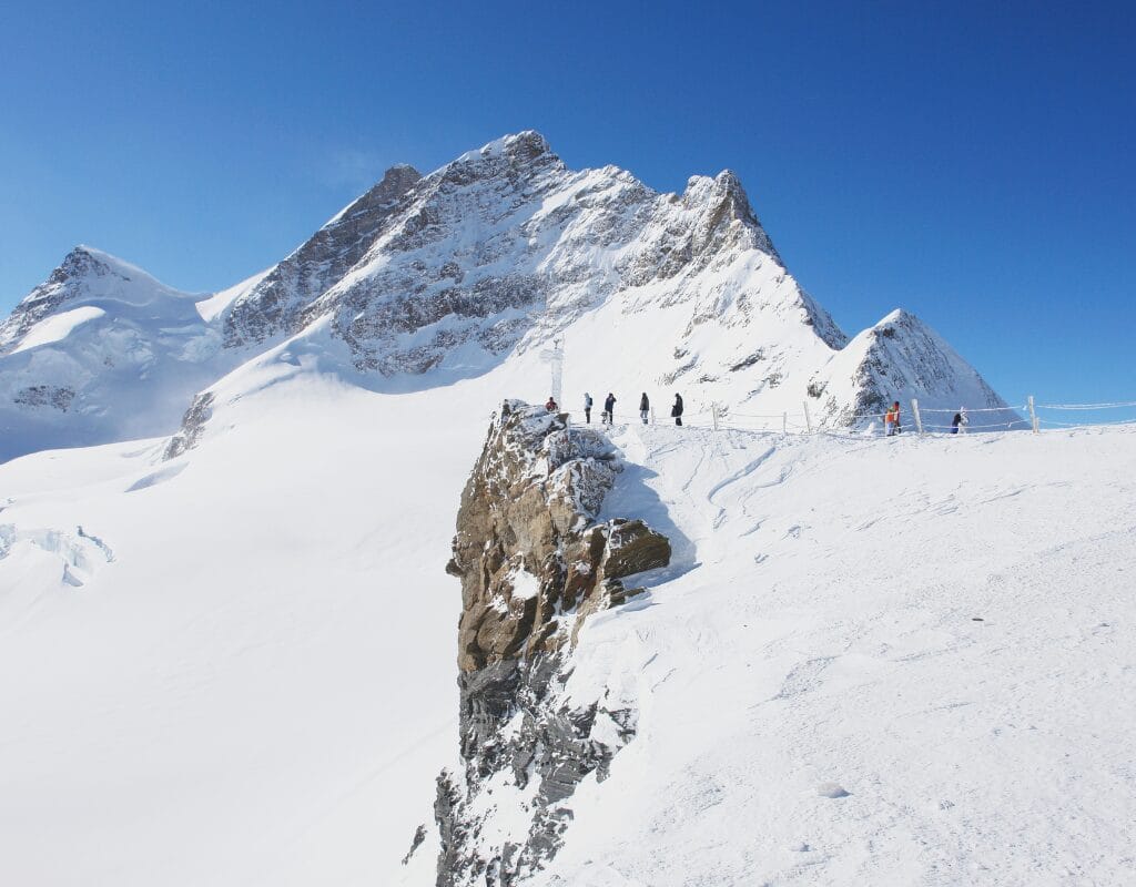 Panoramic view of the Aletsch Glacier under a clear blue sky, highlighting its vast expanse and the surrounding Alpine peaks.