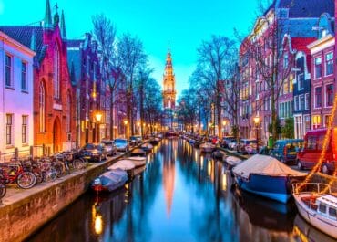 Amsterdam canals with LGBTQ flags, showcasing the city's inclusivity and charm