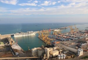 Panoramic view of Barcelona harbor with cruise ships docked.