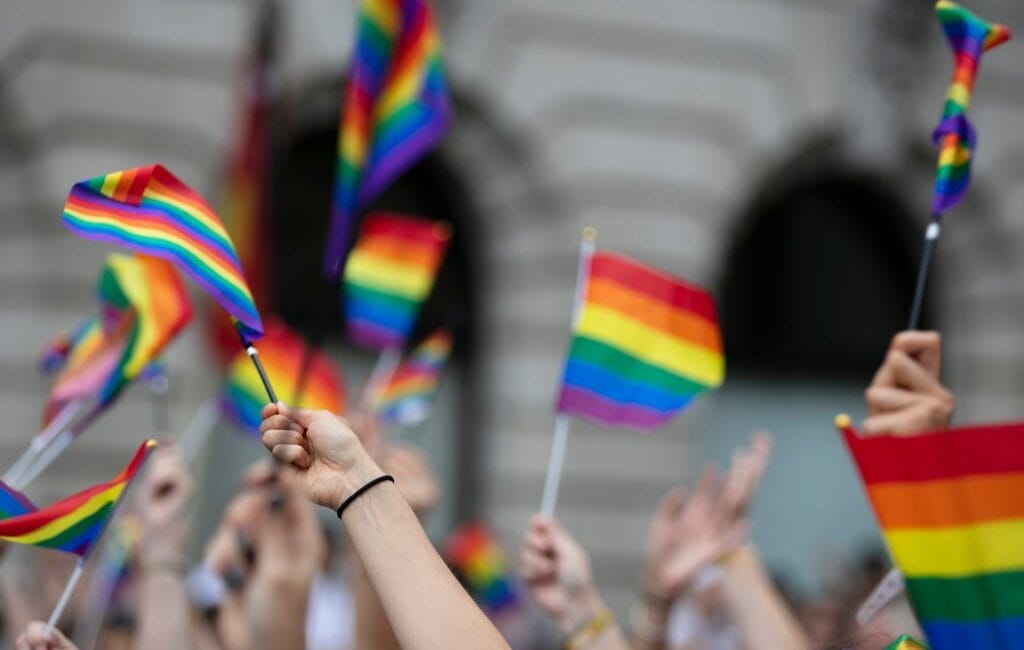 LGBTQ flags waving proudly against the backdrop of Berlin's cityscape, symbolizing the city's open and inclusive spirit.