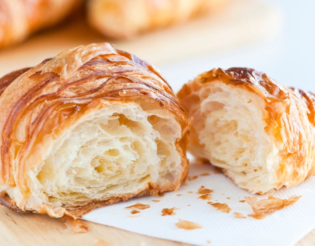 Freshly baked croissants on a baking tray.