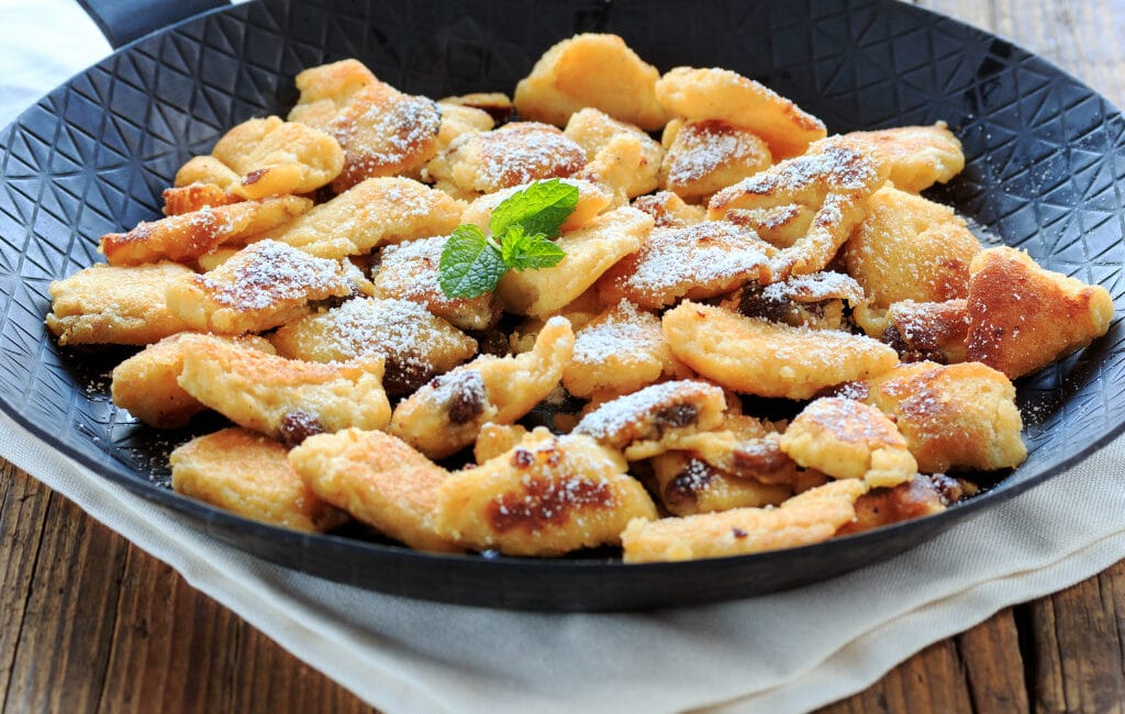 Traditional Austrian Kaiserschmarrn with powdered sugar and fruit compote