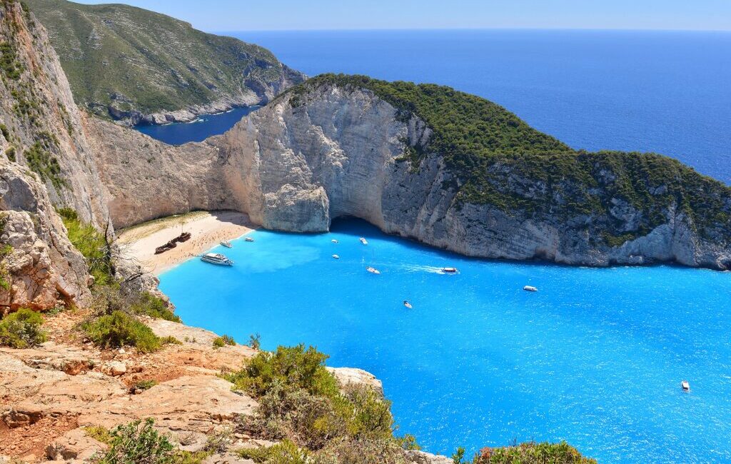 Cliffs surrounding Navagio Beach with turquoise sea in Zakynthos, Greece