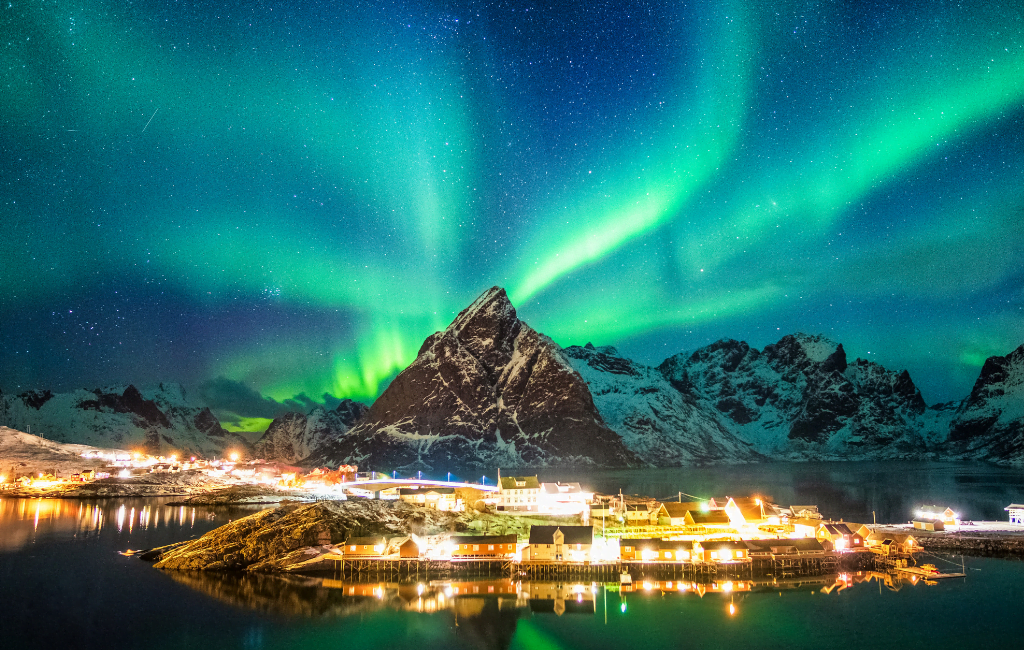 Famous Northern Lights illuminating the Norwegian fjords, casting a magical glow over the dramatic landscapes