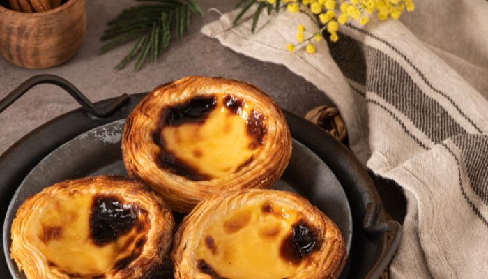 Enjoy freshly baked Pastel de Nata, a traditional Portuguese custard tart.