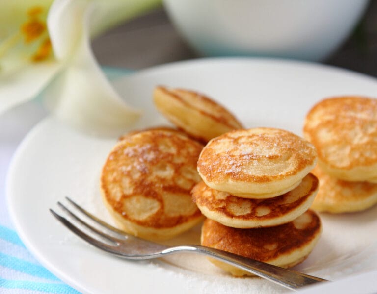 Traditional Dutch poffertjes with powdered sugar and butter