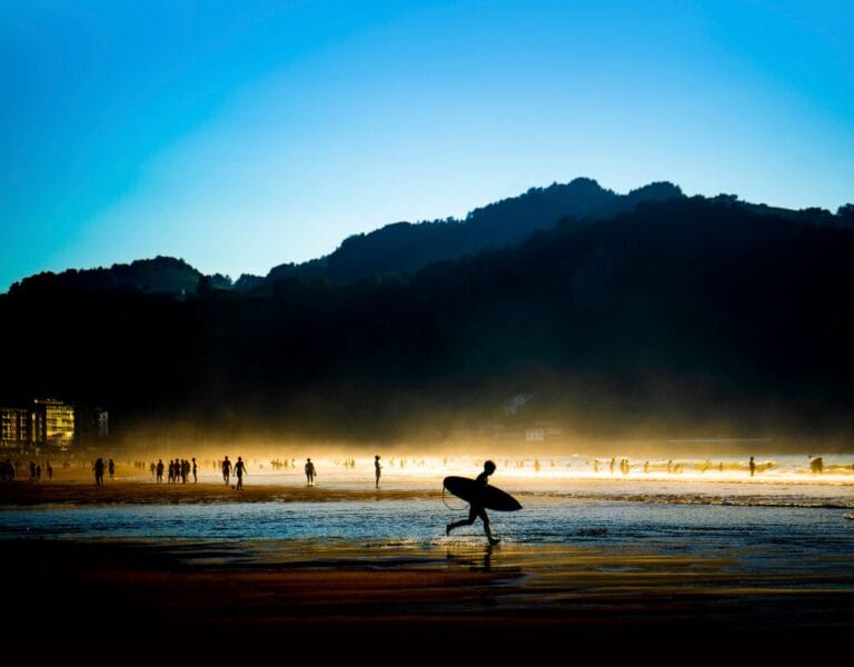 Surfers catching waves at sunset in Vieux Boucau, France's picturesque surf paradise