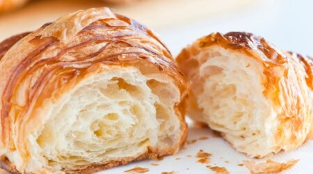 Freshly baked croissants on a baking tray.