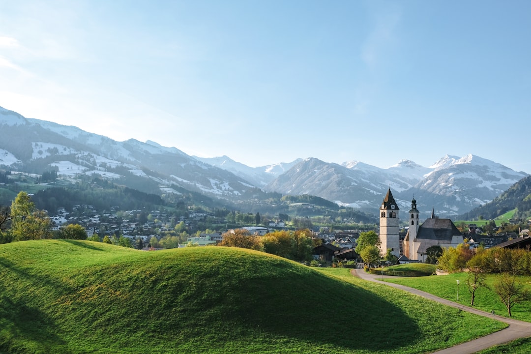 Hilly mountain landscape with the white Alps in the background, representing the challenge of The Streif in Kitzbühel, Austria.