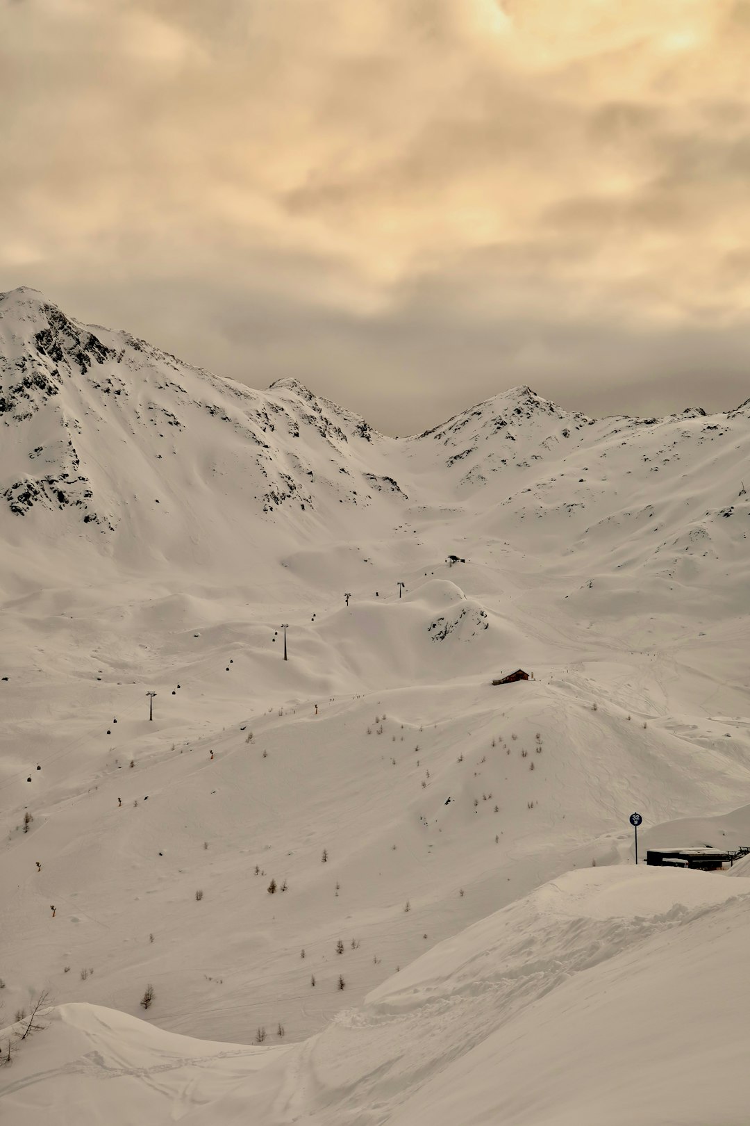 Large ski area illuminated by evening lights with a ski lift in the distance, representing the family-friendly ski village of Zell am See, Austria.