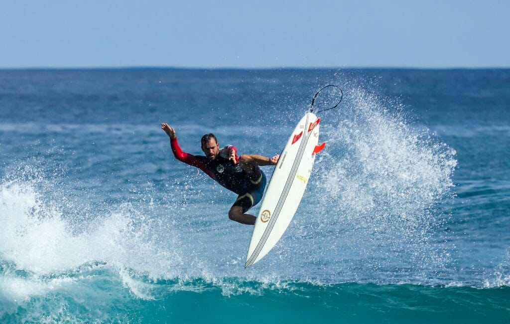 "Surfer tackling a wave in Klitmøller with Denmark's rugged coastline in the background